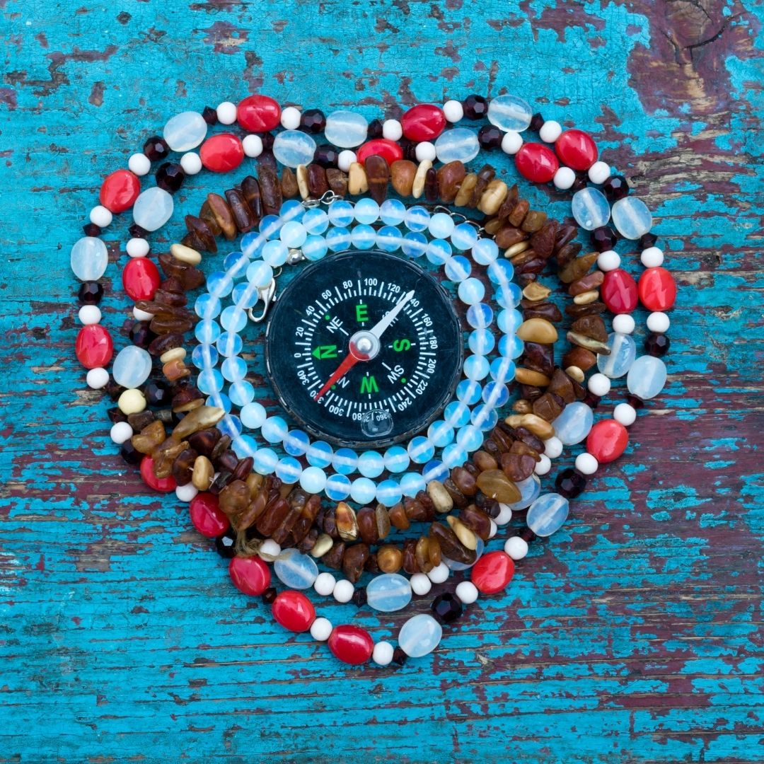 Compass with beads surrounding it in heart shape